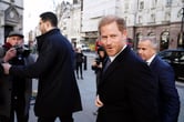 People take photos of Prince Harry as he walks in London.