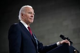Joe Biden rests his hand on a lectern during a speech.