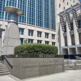 A large grey and white courthouse with many stories and windows.