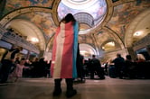 A person stands in the Missouri Statehouse with a transgender flag draped over them.