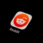 The Reddit app icon is seen on a smartphone.