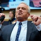 RFK Jr. gestures in front of a microphone
