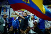 Fernando Villavicencio waves a large Ecuadorean flag during a campaign event.