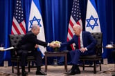 Benjamin Netanyahu shakes hands with Joe Biden as the men sit down for a meeting.