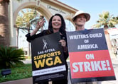 Fran Drescher and Meredith Stiehm hold SAG-AFTRA and WGA protest signs outside the Paramount Pictures studio.