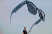 Mark Zuckerberg stands in front of a large screen displaying a new version of Meta’s Ray Ban Stories smart glasses.