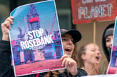 People hold signs while protesting the Rosebank oil drilling project in Edinburgh.
