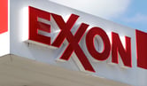 A red Exxon sign on the top of a white awning.