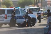 Phoenix, Az police officers arrest a woman lying in the street.