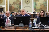 Donald Trump sits at the defense table in a Manhattan courtroom between his attorneys