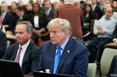 Donald Trump sitting at the defense table in a courtroom