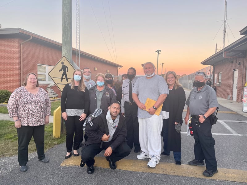 Brandon Jones and Chris Mumma pose with prison staff at the Columbus Correctional Facility in North Carolina on the day of his release.
