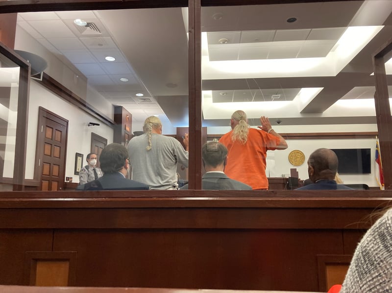 Brandon Jones and Leroy Spruill raise their hands in a courtroom.