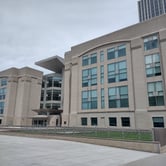 A tan stone building with large windows.