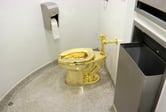 An 18-karat gold toilet in a restroom.