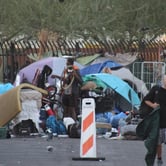 A man walks away from a homeless encampment.