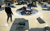 More than a dozen migrants in a gymnasium turned into a makeshift shelter.