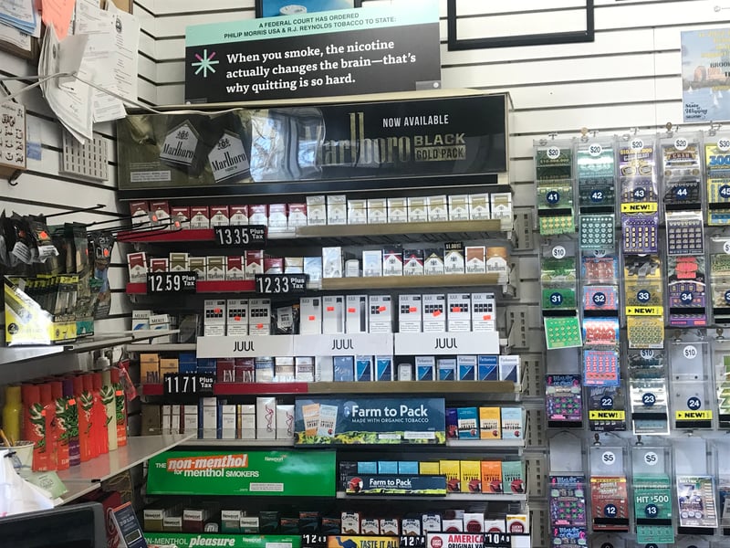 A cigarette sales rack behind the counter of a convenience store.