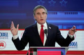 Doug Burgum gestures with his arms while participating in a Republican presidential debate.