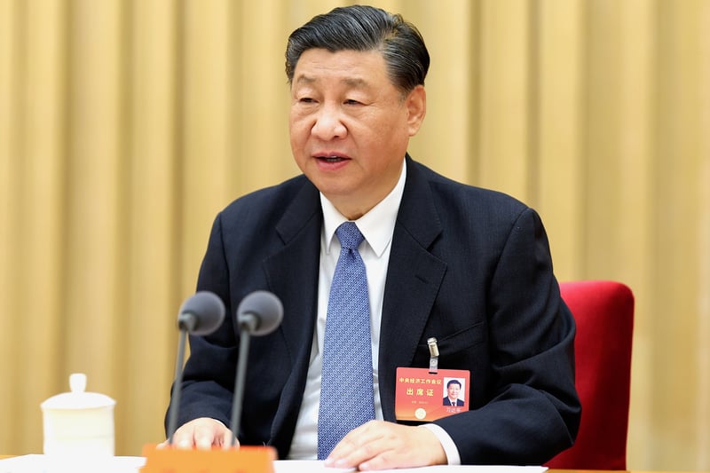 Xi Jinping delivers a speech while sitting at a table during a meeting.