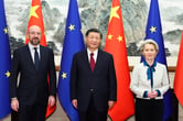 Chinese President Xi Jinping stands for a group photograph with European Commission President Ursula von der Leyen and European Council President Charles Michel, in front of the flags of China and the EU.