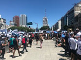 A crowd of people gather in downtown Buenos Aires, brandishing flags and posters.