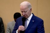 Joe Biden holds a microphone.