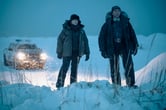 Jodie Foster and Kali Reis look at something off screen while standing on snow during a scene from "True Detective: Night Country."