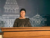 Nancy Unde speaks while standing behind a podium.