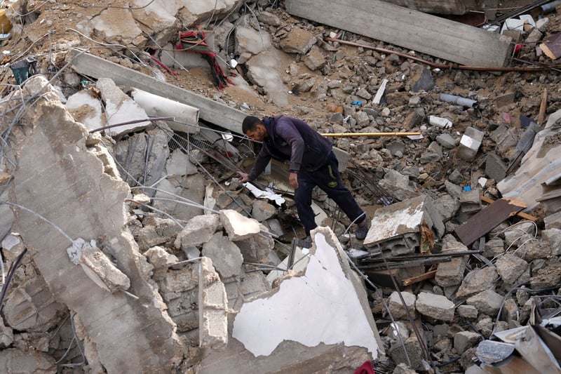 A man climbing over the rubble of a building.