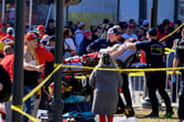 First responders guide a woman in a stretcher after a shooting follow the Kansas City Chiefs' Super Bowl celebration.