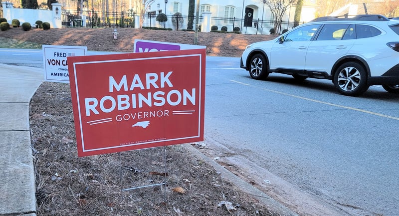 Campaign signs outside of Lake Lynn Community Center. A 'Mark Robinson for Governor' sign is the focus of the photo.