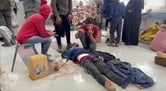 An injured man being treated on a hospital floor.