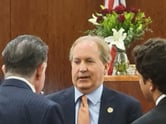 Texas Attorney General Ken Paxton talks to his defense attorneys in a courtroom at the Harris County Criminal Justice Center in Houston on Feb. 16, 2024.