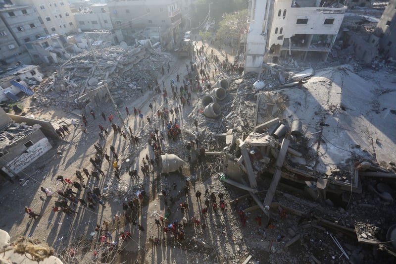An overhead shot of people looking at destroyed buildings.