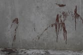 Blood splattered against a gray wall.