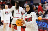 Jannah Eissa prepares to shoot a basketball during pre-game warm-ups as she wears a hijab.
