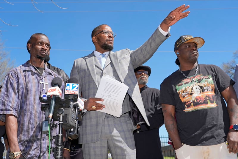 Michael Corey Jenkins, Malik Shabazz and Eddie Terrell Parker stand during a news conference.