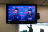 A small television shows Shohei Ohtani speaks during a press conference while sitting next to interpreter Will Ireton.