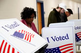 Voters cast fill out their ballots at a polling place.