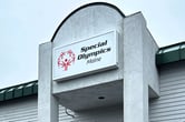 A sign for the Special Olympics Maine on a gray building.