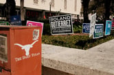 Political yard signs posted on the ground of the University of Texas at Austin.