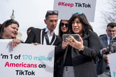People holding cell phones and signs supporting TikTok.