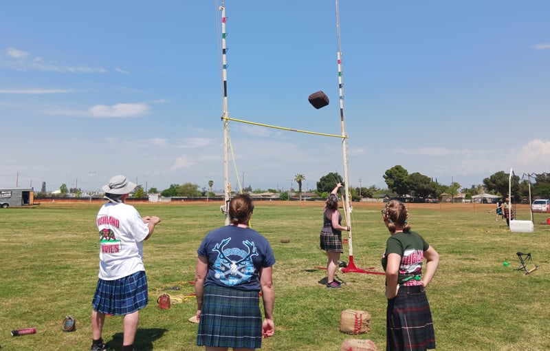 A female competitor flips a mock haybale over the high bar