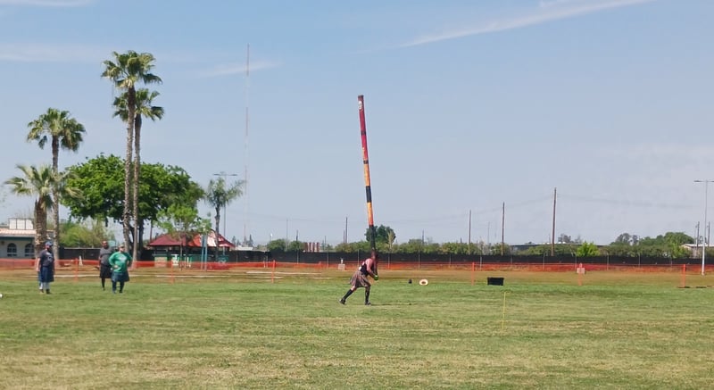 A male contestant throws a wooden pole