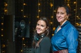 Tessa Kramer and Ellen Horne pose for a portrait in a podcast studio