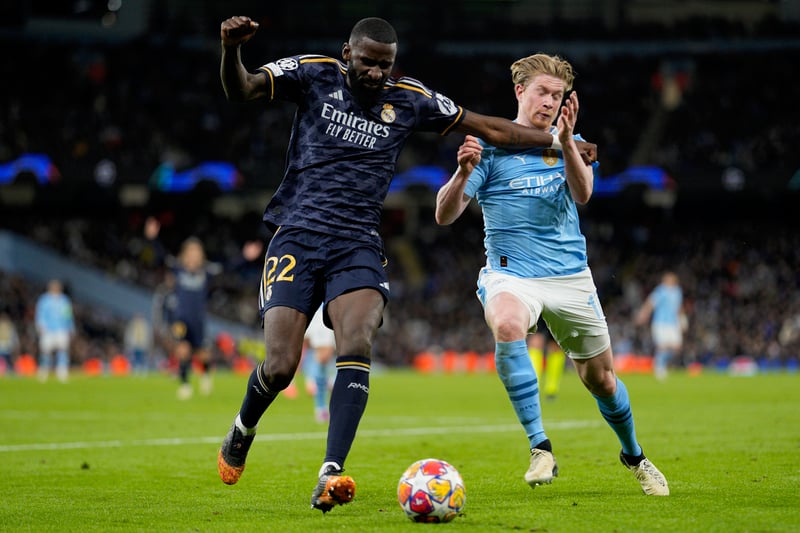 Real Madrid's Antonio Rudiger and Manchester City's Kevin De Bruyne battle each other to get to the ball during a soccer match.