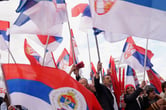 People wave Serbian flags during a rally.