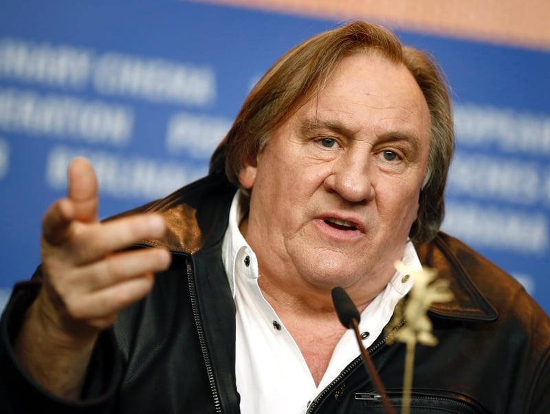 Gérard Depardieu gestures while speaking during a news conference.
