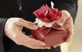 Hands holding a wrapped gift box.